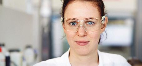Laboratory assistant of FUCHS looking at the camera