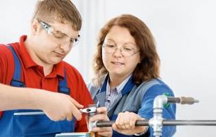 Two FUCHS employees aid one another at work